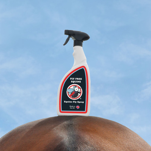 A bottle of fly spray stood on a horse's back with blue sky in the background.