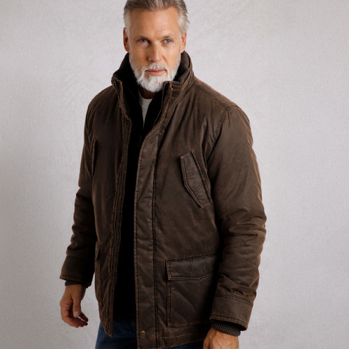 A man wearing a dark brown padded jacket with a high collar and visible stitching. The jacket features flap pockets on the chest and lower front.