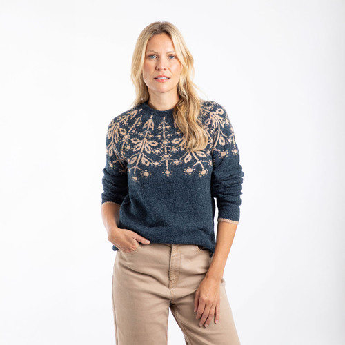 A woman wearing a navy knitted jumper with a fair isle patterned yoke.