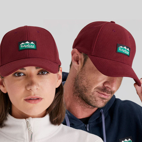 A man and woman wearing a berry coloured Ridgeline cap.