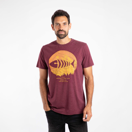 A man wearing an aubergine coloured t-shirt with a yellow fish print in the centre.