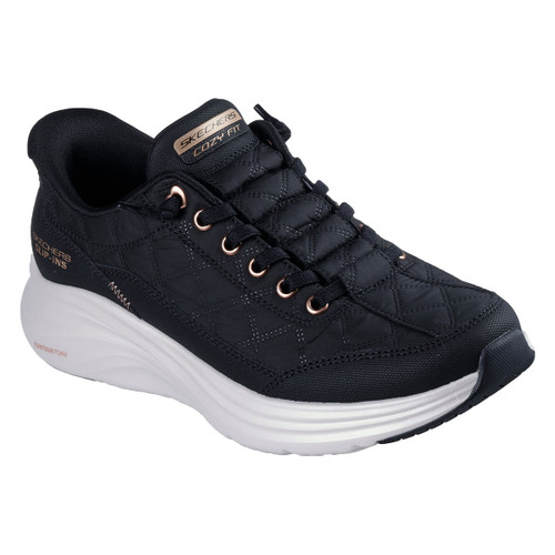 Angled view of a black Skechers Slip-ins trainer featuring a quilted upper, rose gold eyelets, and bungee laces. The shoe includes a raised white sole with “Contour Foam” branding and “Cozy Fit” detailing on the tongue.