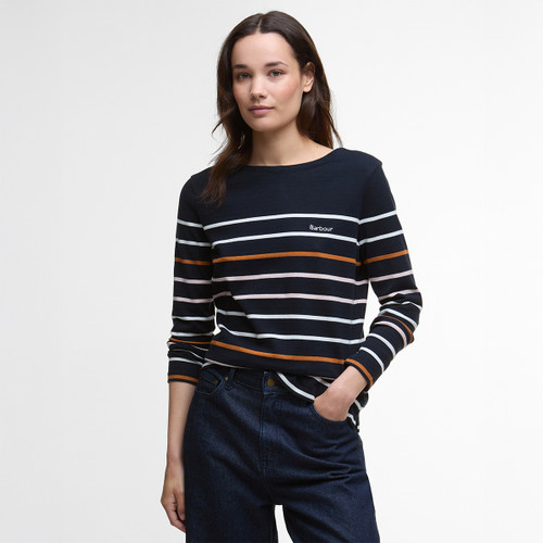 A person wearing a black long-sleeve shirt with horizontal stripes in white, orange, and pink, paired with dark jeans. The expression is neutral.