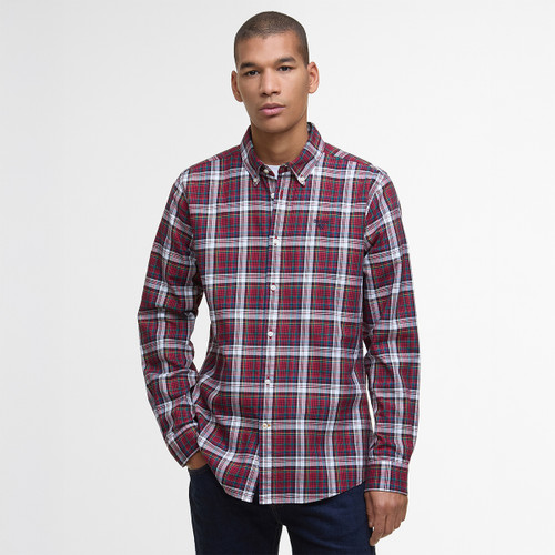A man stands against a plain white background, wearing a red, blue, and white plaid button-up shirt. He has a neutral expression and dark jeans. A man stands against a plain white background, wearing a red, blue, and white plaid button-up shirt. He has a neutral expression and dark jeans.