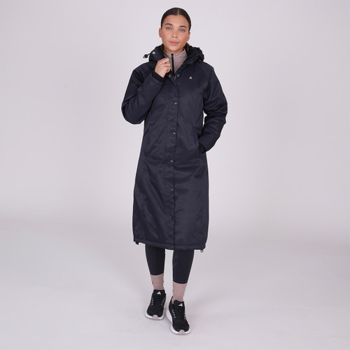 A front view of a woman wearing a full length Shires Aubrion waterproof coat