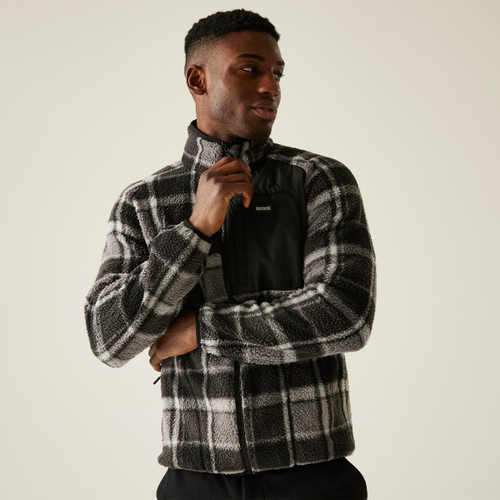 A male model wearing a black and grey check fleece jacket with full zip and high collar, shown mid-zip against a plain beige backdrop. A male model wearing a black and grey check fleece jacket with full zip and high collar, shown mid-zip against a plain beige backdrop.