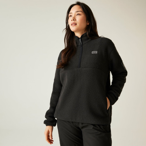 Front view of a woman wearing the Dare 2b Slide Out Fleece in Fig, with hands in pockets and head turned slightly to the left.