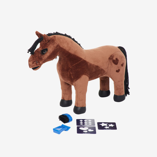 A brown plush toy horse with a dark brown mane and tail, standing on a white background. The horse has a lighter brown patch on its back and hindquarters with heart-shaped markings. In front of it are blue grooming accessories, including a brush, a curry comb, and two stencil cards featuring diamond, heart, and star shapes.