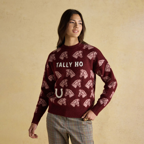 Model wearing red Tally Ho jumper with horse design and slogan, styled with checked trousers