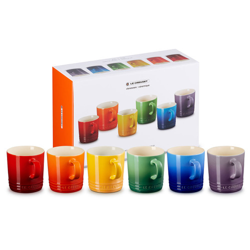 A set of six mugs in red, orange, yellow, green, blue, purple positioned in front of their box.