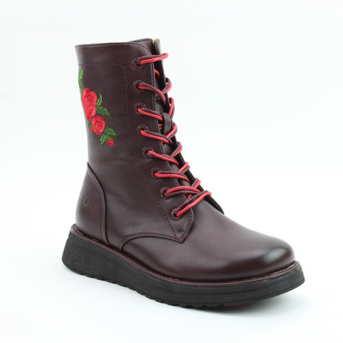 A view of a tall lace up boot with a rose design on it on a white background