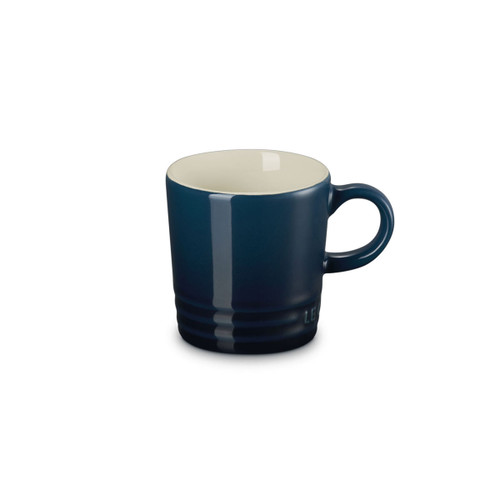 Navy blue stoneware mug with cream interior, side view with handle.