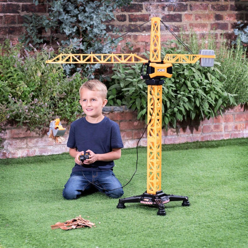 Child playing outdoors with Teamsterz JCB X-Series Crane toy using wired remote control to lift and move objects.