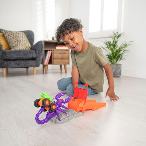 Young boy playing with Teamsterz Beast Machines Stinger Slam monster truck playset with purple scorpion and orange ramp.