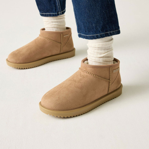 Tan suede ankle boots with soft fleece lining and textured soles, worn with cream socks and blue jeans.