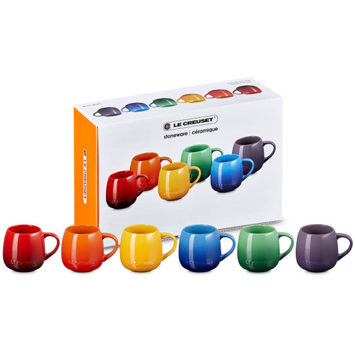 A boxed set of six Le Creuset stoneware Coupe Mugs in assorted colours, shown in front of the packaging.