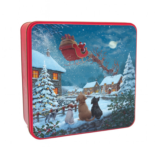A view of a Grandma Wild's biscuit tin on a white background showing dogs watching Santa fly over a snowy village