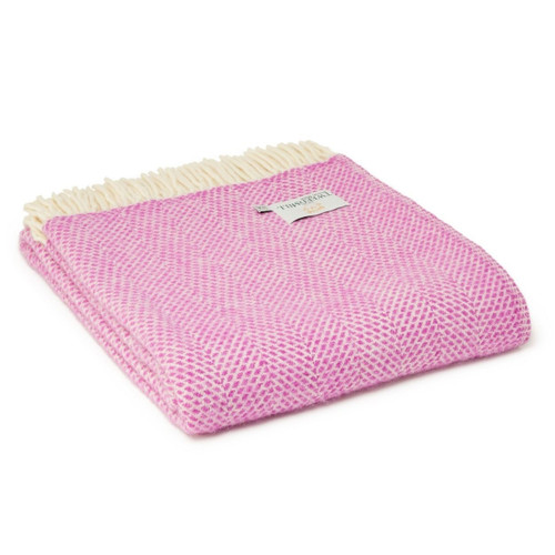 A folded pink wool blanket with a beehive pattern and cream fringe.