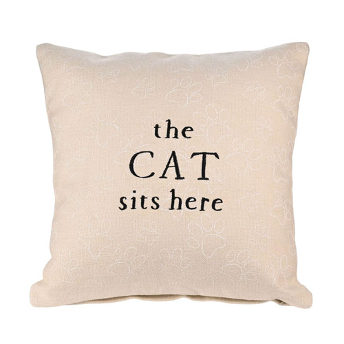 Cream cushion with embroidered paw prints and the phrase “the CAT sits here” stitched in black lettering on the front.