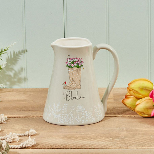 A view of a green jug with the welsh word Blodau and a pair of wellies on it