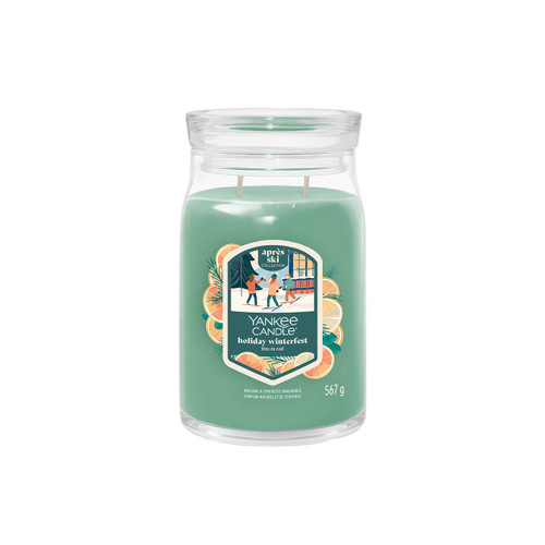 A large green Yankee Candle in a clear glass jar with two wicks unlit. The label reads “Holiday Winterfest”.