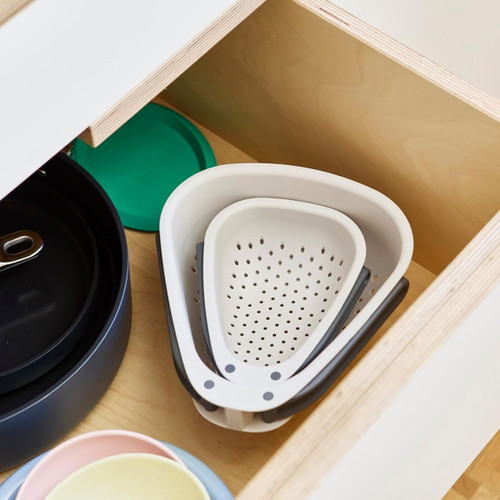 Set of Joseph Joseph Nest Colanders neatly stacked in a kitchen drawer for compact storage.