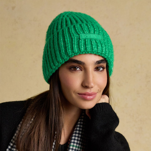 Model wearing a bright green knitted beanie with ribbed design and Joules logo patch on the front