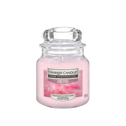 A glass jar candle with pink wax labeled "Yankee Candle Home Inspiration: Fairy Floss." The design is simple and evokes a sweet, cozy feeling. A glass jar candle with pink wax labeled "Yankee Candle Home Inspiration: Fairy Floss." The design is simple and evokes a sweet, cozy feeling.