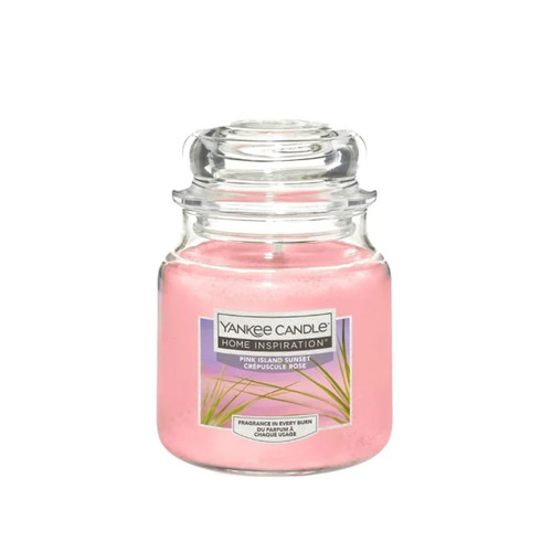 A jar of Yankee Candle labeled "Home Inspiration, Pink Island Sunset." The candle wax is soft pink, creating a serene and calming atmosphere.