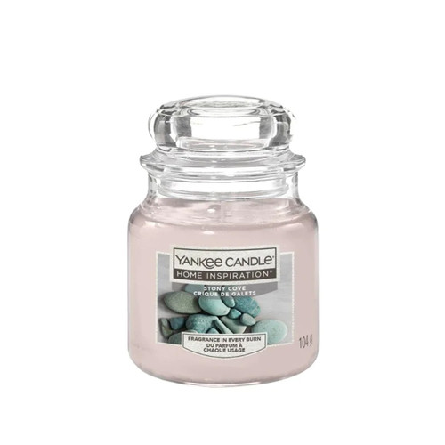 Glass jar of Yankee Candle's "Stony Cove" scent, part of the Home Inspiration series. The label shows smooth, blue stones, creating a tranquil vibe.