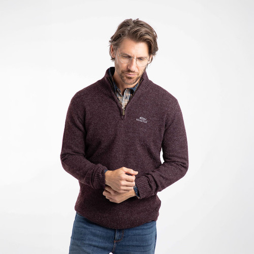 Man wearing an aubergine quarter-zip jumper with a checked shirt underneath.