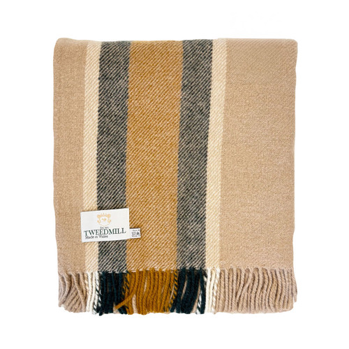 A folded Tweedmill wool blanket in neutral tones, featuring wide mustard yellow and grey stripes against a beige background, with a fringed edge.