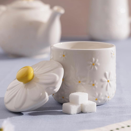 Price & Kensington Daisy ceramic sugar bowl with matching daisy-shaped lid and yellow knob, styled with sugar cubes on a blue tablecloth.