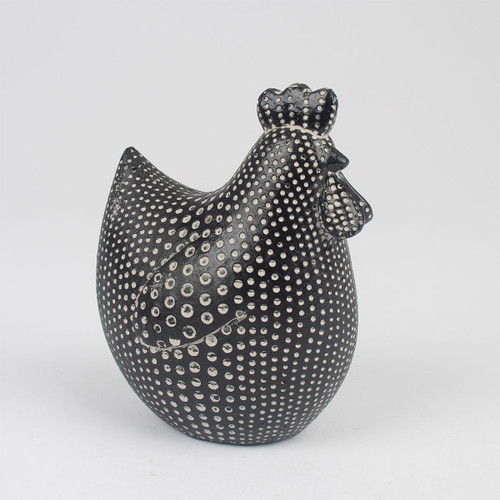 A black and white hen figurine with polka dots stands against a plain white background. The dotted pattern gives it a whimsical appearance.