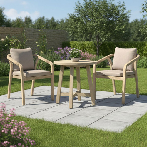 Outdoor bistro set on patio with wooden round table and two cushioned armchairs surrounded by a green garden.