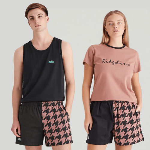 Two people wearing black shorts with a pink geometric pattern on one side and solid black on the other.