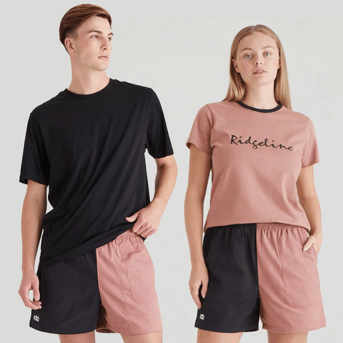 Two-tone shorts with a split design—one half black and the other dusty pink—featuring an elastic waistband, a relaxed fit, and a simple, casual style.