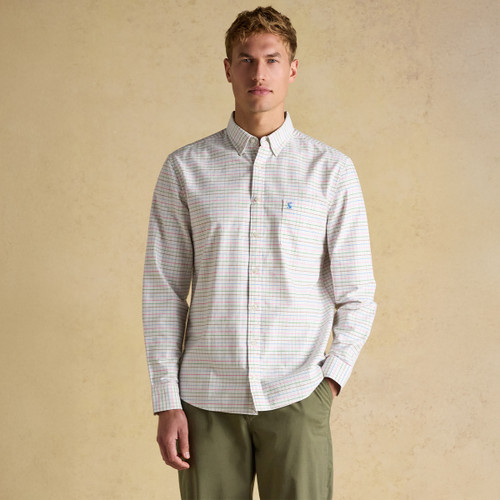 Front view of a model wearing a men’s white multicoloured check Oxford shirt styled with green chinos.