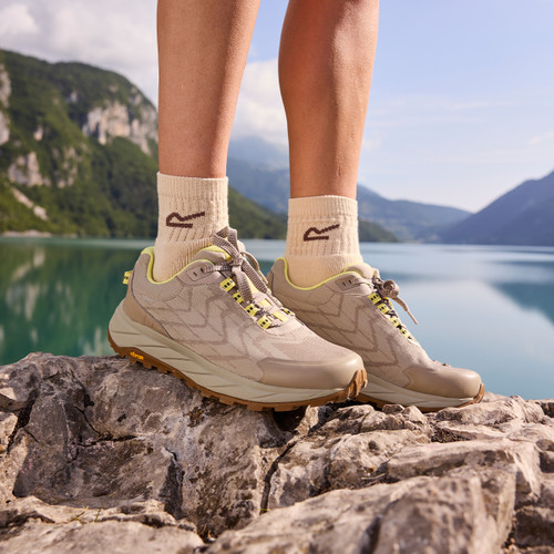 Person wearing Regatta Cruize hiking shoes standing on rocks by a mountain lake.