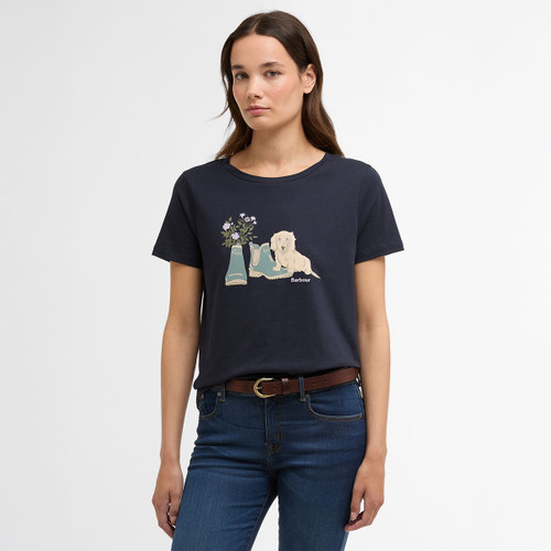 Model wearing a navy short-sleeve Barbour T-shirt with illustrated wellies, flowers and a dog graphic on the chest.
