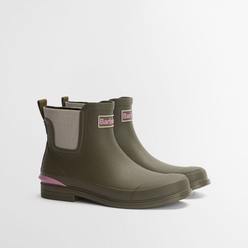 Olive green Barbour Chelsea wellington boots with rubber upper, low block heel and pink Barbour logo detail, photographed at a three-quarter angle on a white background.