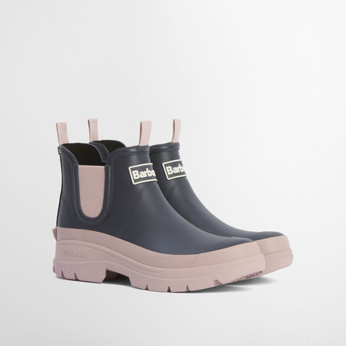 Pair of Barbour navy Chelsea wellington boots with blush pink chunky soles and elastic side panels on a white background.