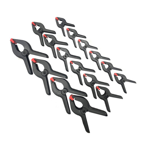 A set of 16 black plastic spring clamps with red tips, arranged diagonally in rows. The clamps vary in size, creating a sense of order and precision.
