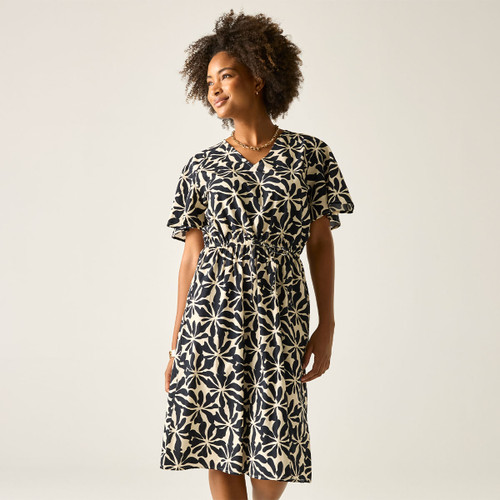 Model wearing a cream and navy floral print V-neck dress with short sleeves and a drawstring waist, standing against a light background.