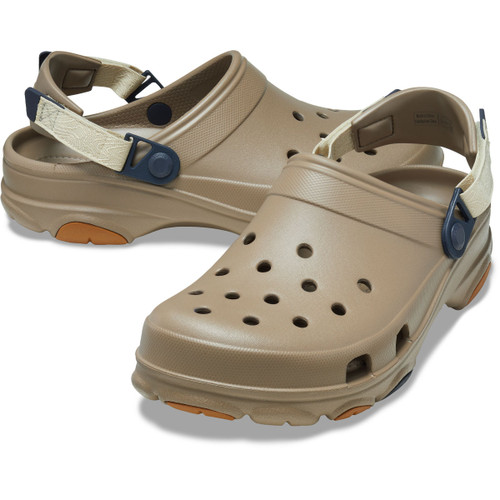 Pair of khaki Crocs clogs with textured sole and fabric heel strap, displayed at an angled side view.