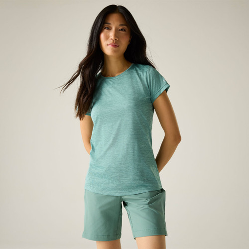 Model wearing a green short-sleeve crew-neck T-shirt with green shorts, standing against a light studio background.