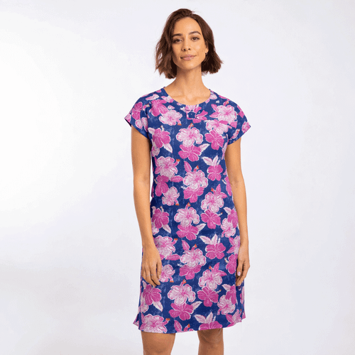 Woman wearing a navy blue short-sleeve dress with a pink and white floral print and round neckline.