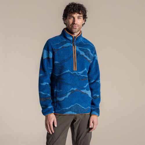 Male model standing in a studio wearing a blue patterned Craghoppers half-zip fleece with walking trousers.