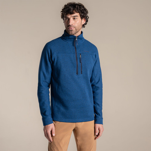 Model wearing a blue long-sleeve half-zip fleece with a high collar and zipped chest pocket, front view.