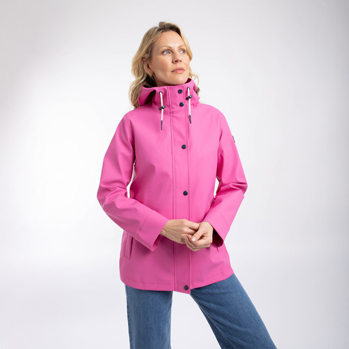 Model wearing the bright pink rain jacket fastened up with a high collar, standing in a studio setting.
